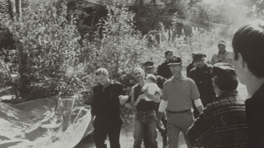 Bo Gritz and FBI agents escort Randy Weaver down the mountain on August 31, 1992. Bo Gritz is on the left and Randy Weaver is in the center holding his daughter.